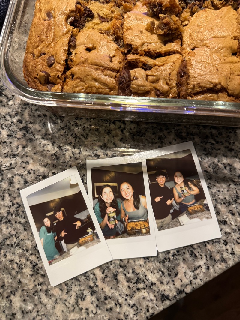 A tray of cookies and three instant photographs on a kitchen counter.